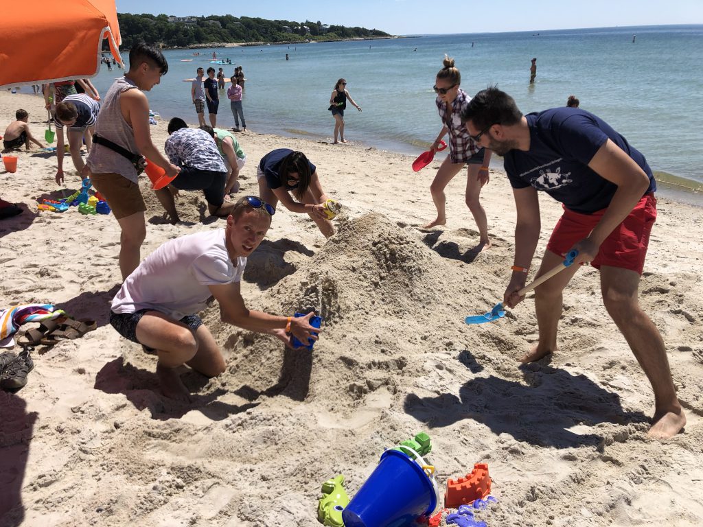 Lab members building a sand sculpture.